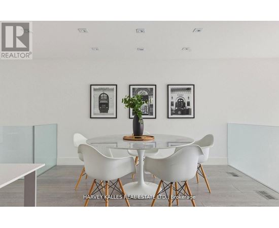 A dining room with a table and chairs and pictures on the wall.