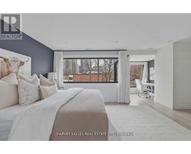 A bedroom with a large bed and a cow print pillow.