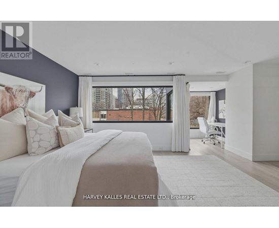 A bedroom with a large bed and a cow print pillow.