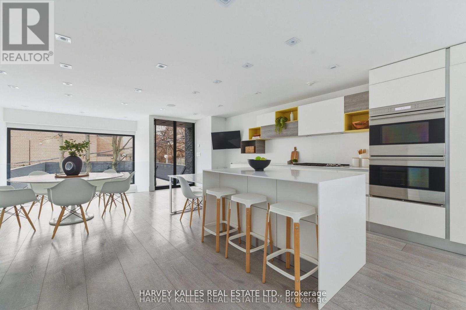A modern kitchen with white cabinets and a bar area.