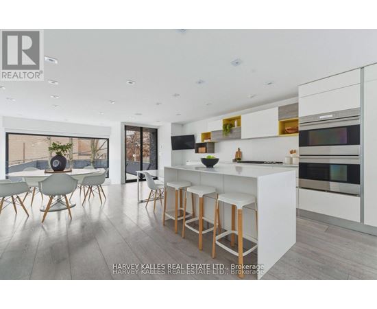 A modern kitchen with white cabinets and a bar area.