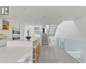 A modern interior space with a staircase leading to the upper level.