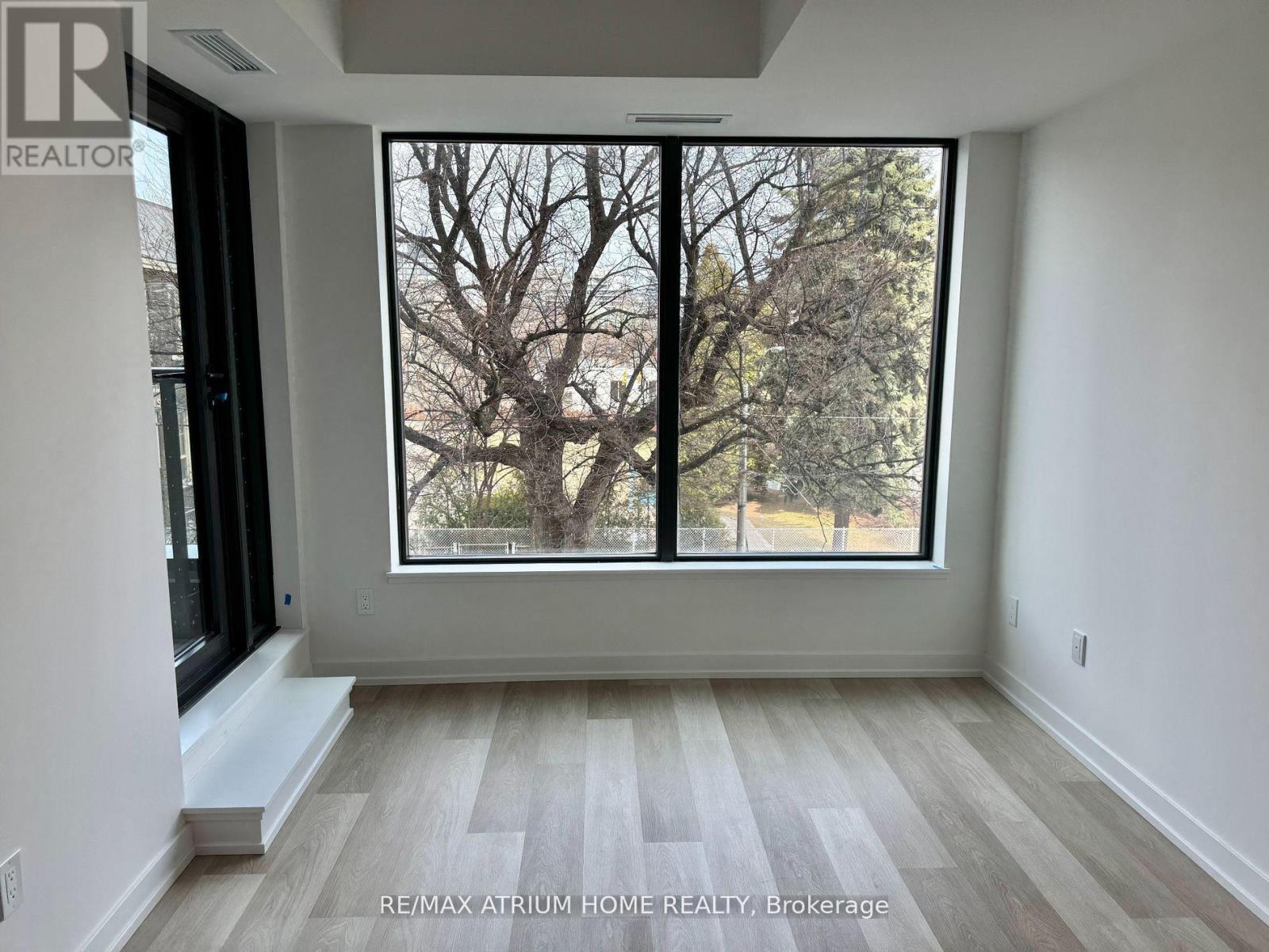 A room with a large window showing a tree outside.