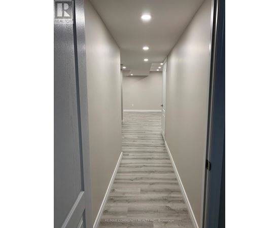 A hallway with a wooden floor and white walls.