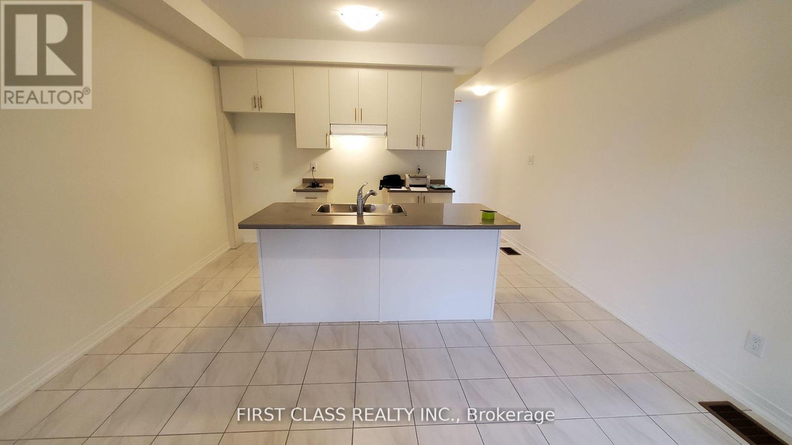 A kitchen with white cabinets and a white island.