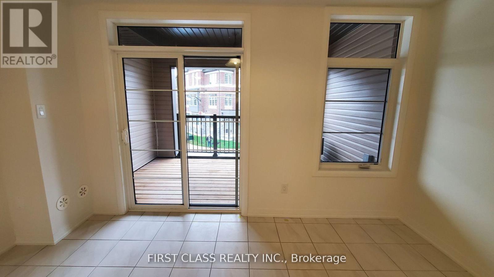 A room with a sliding glass door leading to a balcony.