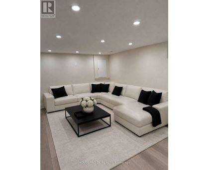A modern living room with a white sofa and a coffee table.