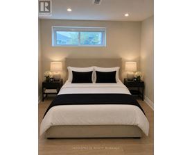 A bedroom with a large bed and two nightstands.