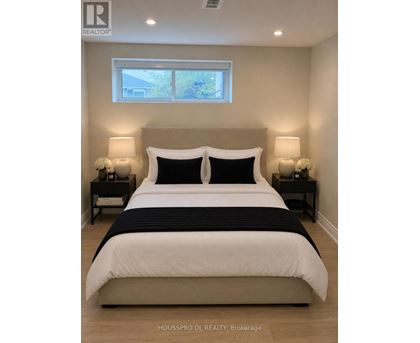 A bedroom with a large bed and two nightstands.
