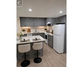 A modern kitchen with white appliances and a dining table set for two.