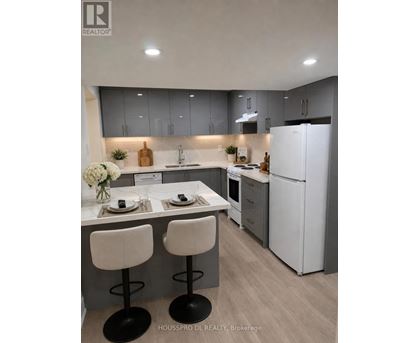 A modern kitchen with white appliances and a dining table set for two.