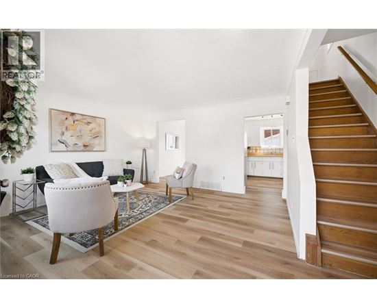 A living room with a white chair and a wooden floor.