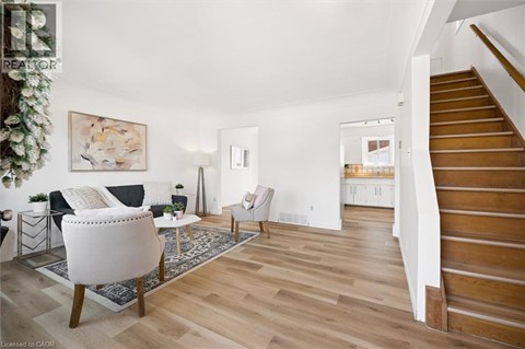 A living room with a white chair and a wooden floor.