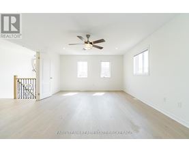 A spacious room with a ceiling fan and hardwood floors.