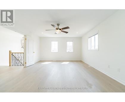 A spacious room with a ceiling fan and hardwood floors.