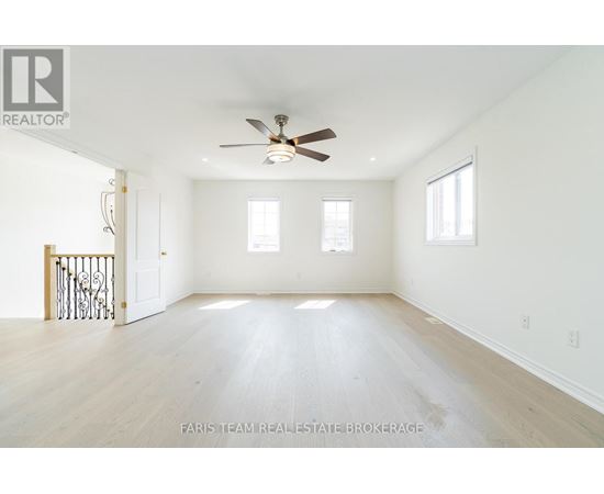 A spacious room with a ceiling fan and hardwood floors.