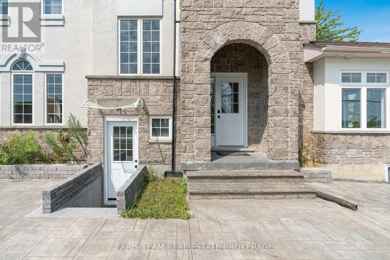 A stone house with a grey door and windows.