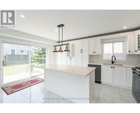 A kitchen with white cabinets and a large island.