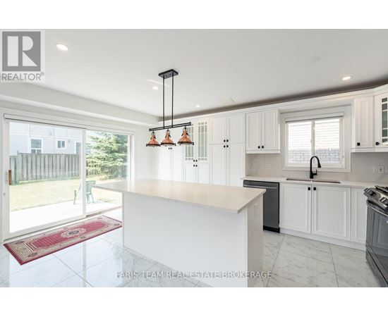 A kitchen with white cabinets and a large island.