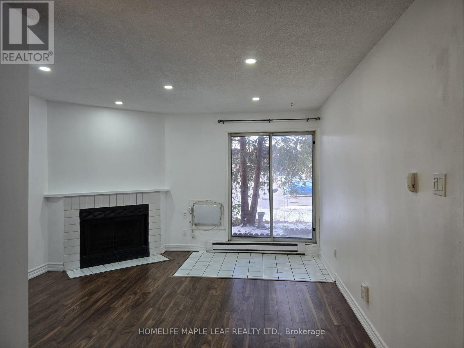 A room with a fireplace and a sliding glass door.