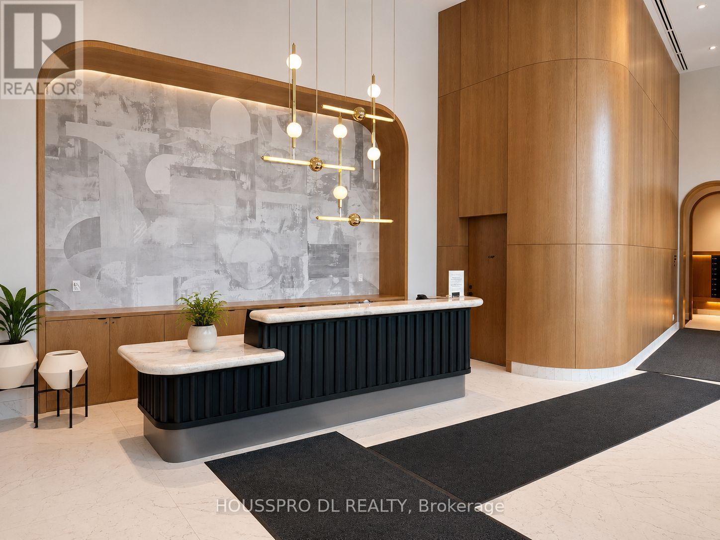 A reception area with a black and white marble wall and a wooden pillar.