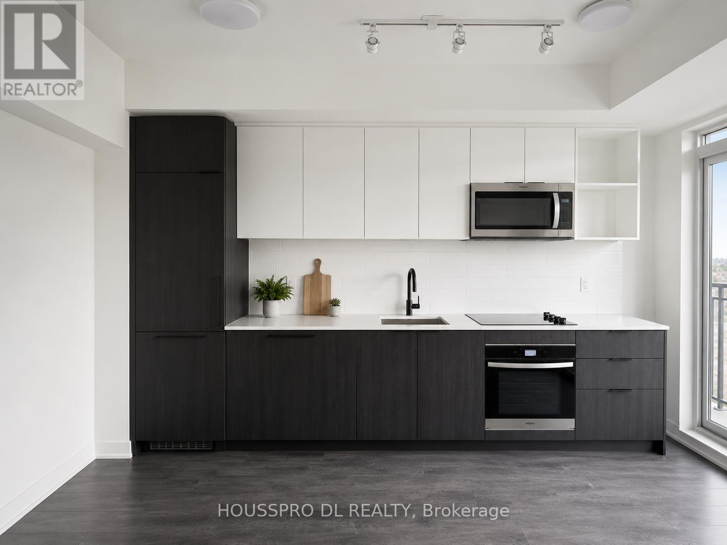 A modern kitchen with black cabinets and a white countertop.