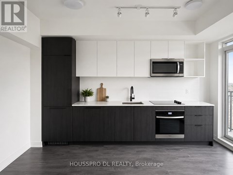 A modern kitchen with black cabinets and a white countertop.