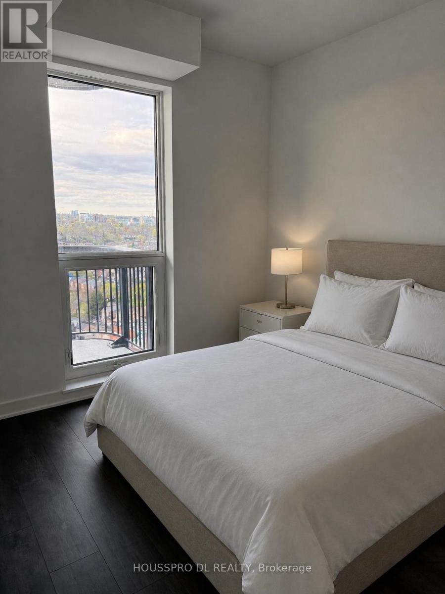 A bedroom with a large bed and a view of the city through the window.