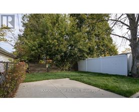 A white fence and green trees are visible in the image.