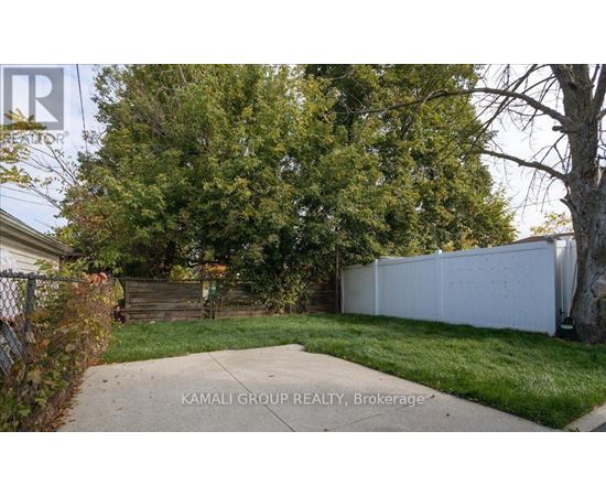 A white fence and green trees are visible in the image.