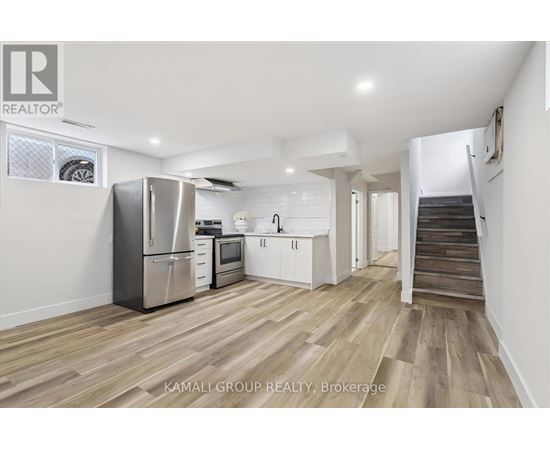 A kitchen with a refrigerator, microwave, and oven is shown in a real estate listing.