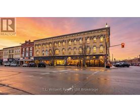 A street view of a building with the sign T.L. Willaert Realty Ltd Brokerage.