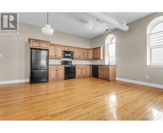 A kitchen with wooden cabinets and black appliances.