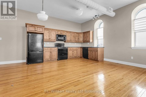 A kitchen with wooden cabinets and black appliances.