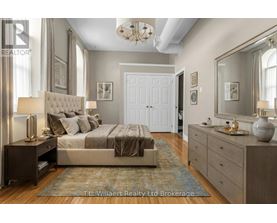 A bedroom with a large bed, a dresser, and a mirror.