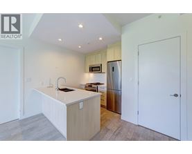 A kitchen with a white countertop and a stainless steel refrigerator.
