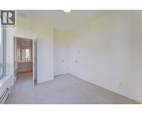 A spacious room with white walls and a carpeted floor.