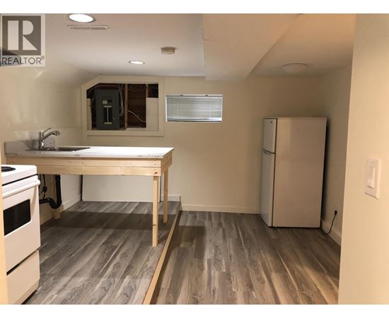 A kitchen with a table and a refrigerator.