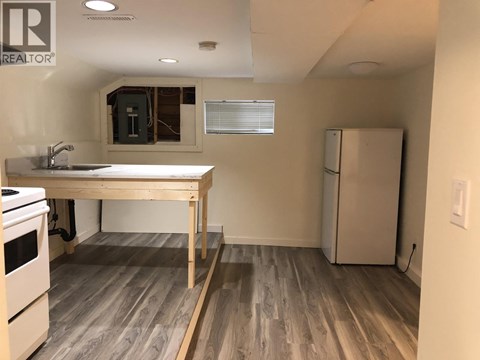 A kitchen with a table and a refrigerator.