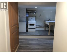 A kitchen with a white fridge, stove, and sink.
