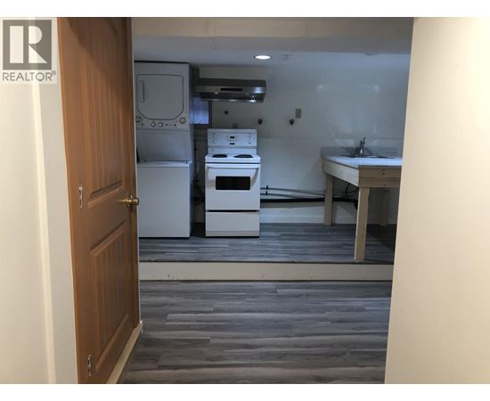 A kitchen with a white fridge, stove, and sink.