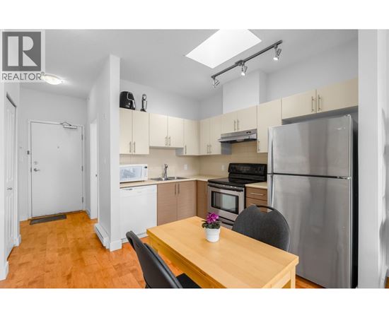 A kitchen with a table and chairs in the foreground and a refrigerator in the background.