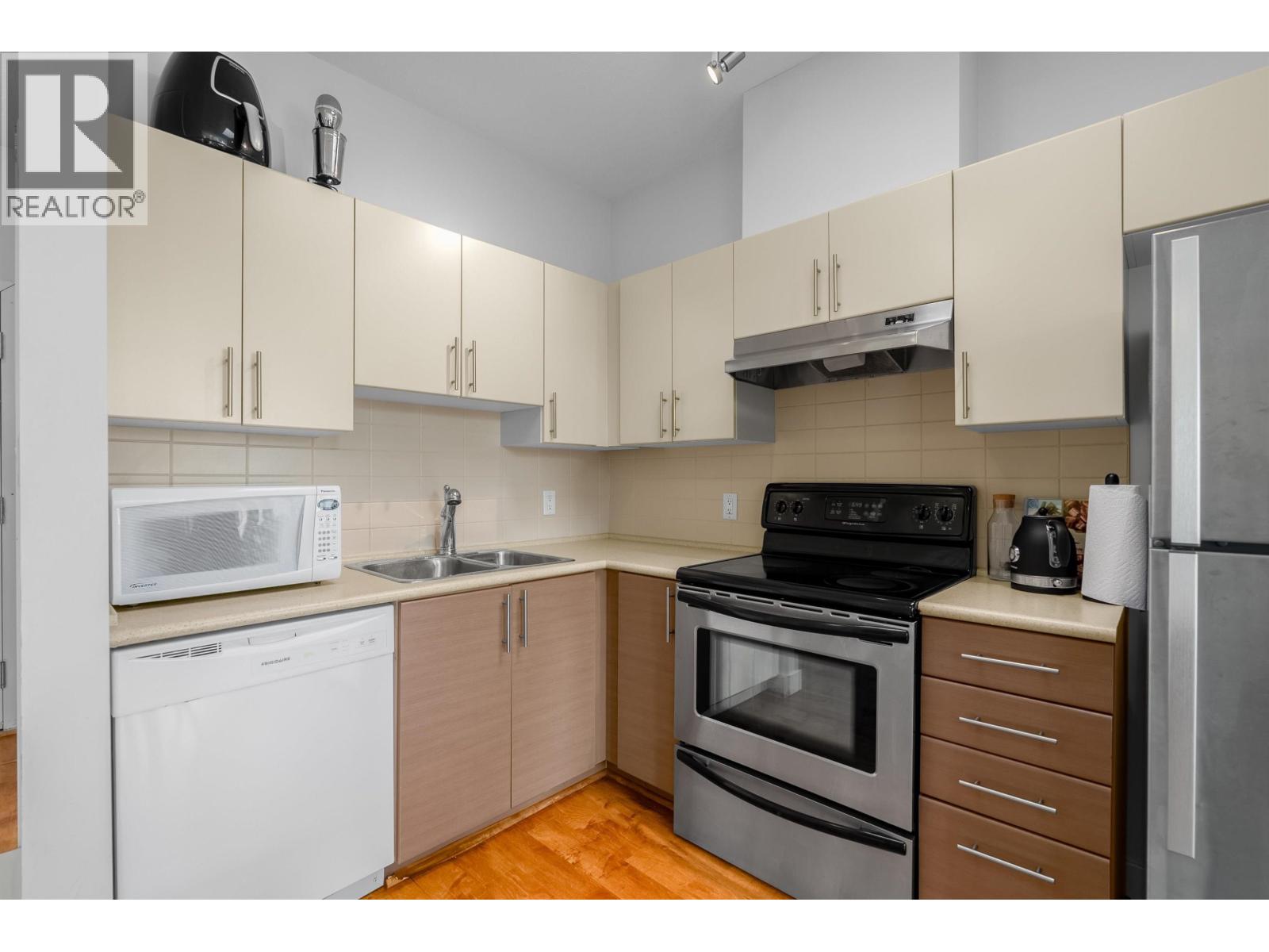 A kitchen with a black stove top oven, white dishwasher, and a white microwave.