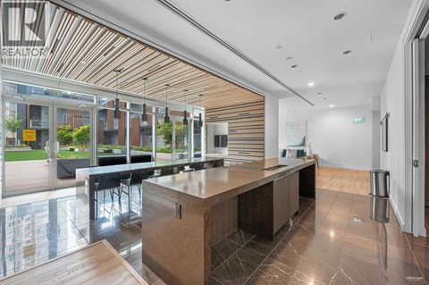 A modern kitchen with a wooden island and black chairs.