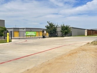 A large industrial building with a green sign on it.