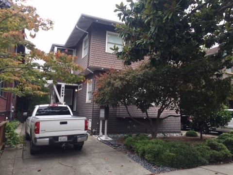 A white pickup truck is parked in front of a house.