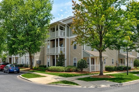 Apartment building with a tree in front of it.