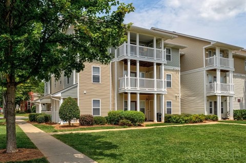 Apartment building with a tree in front of it.