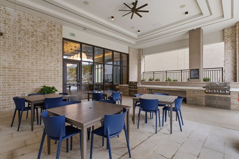 A dining area with a wooden table surrounded by blue chairs.