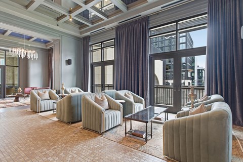 A living room with grey couches and a glass table.